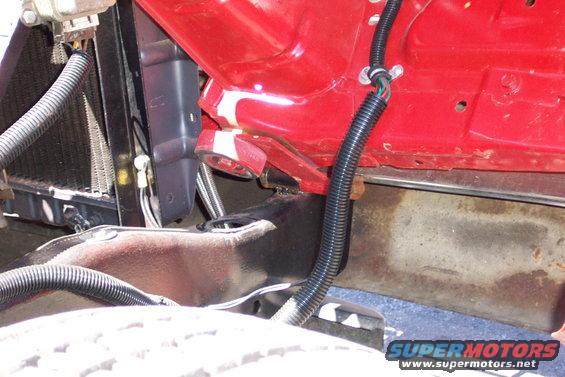 Close-up of car's front chassis, radiator, and red painted engine bay components