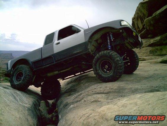 1997 Ford Ranger climbing rocks, two-tone paint, lifted suspension