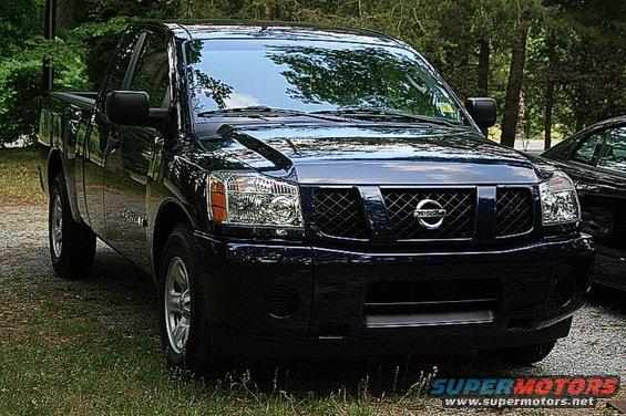 Dark blue 2007 Nissan Titan pickup truck parked outside with trees in the background