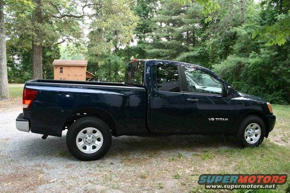 Dark blue pickup truck, side view, with V8 TITAN badging