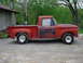 1965 Ford F-100 - Side view of a 1965 Ford F-100 pickup truck with red paint and aftermarket wheels.