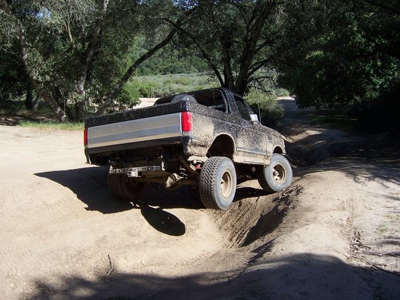 1991 Ford Bronco 3q-front view, mud-covered, on a dirt trail