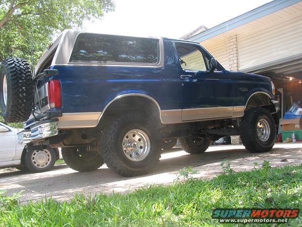 Blue 1996 Ford Bronco with a lift kit and spare tire on the rear