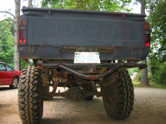 Lifted Toyota pickup truck rear view with large off-road tires and custom bumper