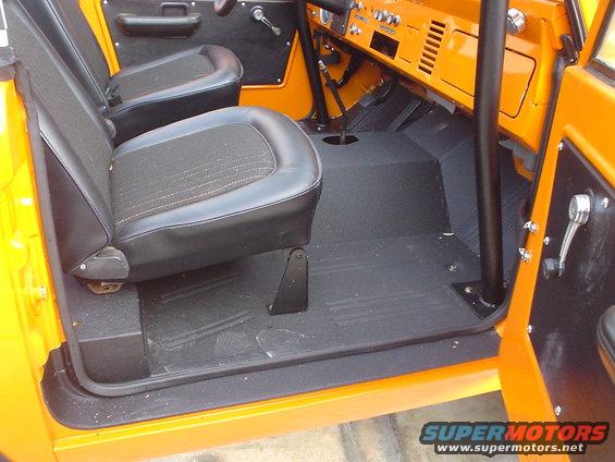 Interior of a 1977 Ford Bronco showing front seats, dashboard, and floor