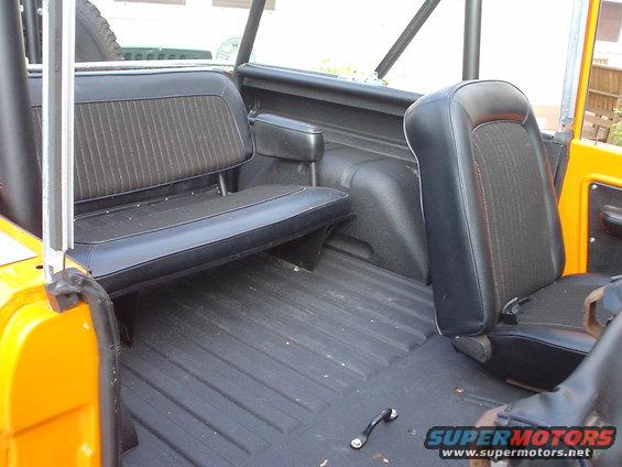 Orange SUV interior with black vinyl seats and a roll cage. A Supermotors logo is visible