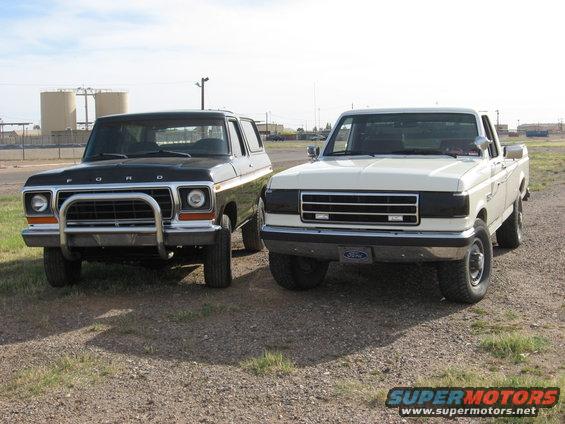 1989 Ford F-250 and a black Ford Bronco parked on gravel