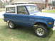 1996 Ford Bronco - This classic blue and white Ford Bronco is shown from a 3/4 front angle, with the iconic "Bronco" script visible on the fender.