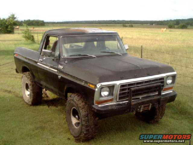 Black 1978 Ford Bronco with a brush guard and winch, viewed from the front-left