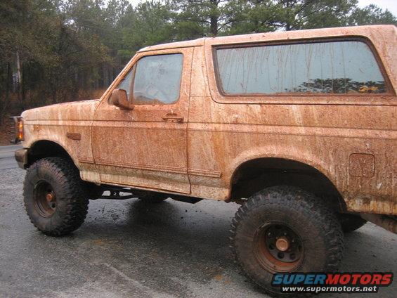 Mud-caked SUV, side view. Off-road tires visible