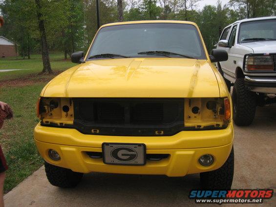 Yellow Ford Ranger pickup truck front view with missing headlights