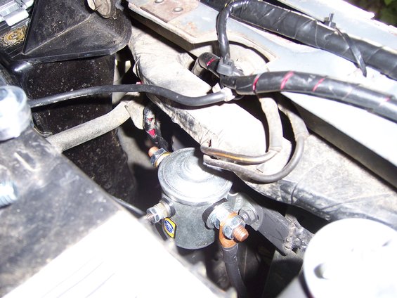 100_3773.jpg A NAPA continuous duty solenoid. I welded a 1" bar with studs (i like studs) from the two post in order to mount it since i couldn't find anywhere else I liked enough to mount it. It's a 3 pole so It's a self grounding unit. I prefer that since it's one less wire to run. From the Solenoid to the fan, I ran 10 gauge wire since the wire on the fan was only 10 gauge. 