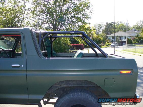 Green 1978 Ford Bronco side view with roll cage