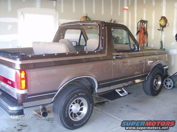 Brown Ford Bronco with removable top, parked in a garage
