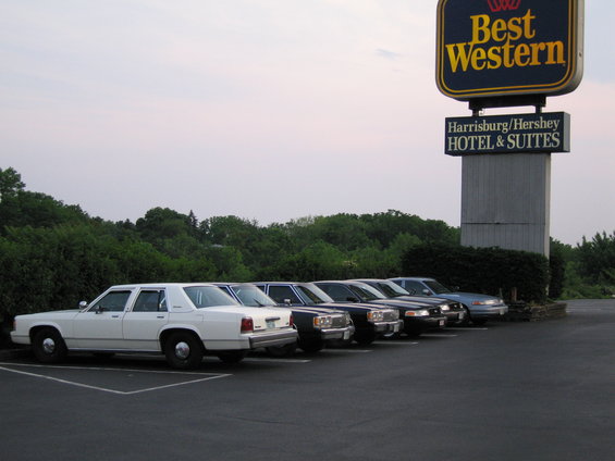 White Ford Crown Victoria sedan parked in a lot, side view