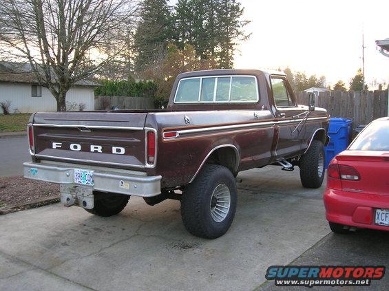Brown Ford pickup truck parked in driveway, red car next to it
