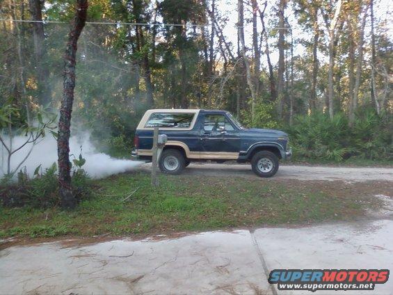 1986 Ford Bronco side view, emitting white smoke from exhaust