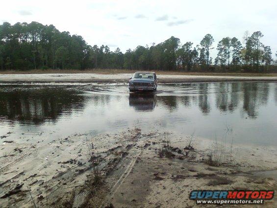 1986 Ford Bronco driving through shallow water