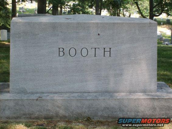 Large granite tombstone with the name BOOTH carved into it, set in a grassy cemetery