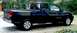 2007 Nissan Titan - A black 2007 Nissan Titan pickup truck is shown from the side, parked outdoors on a gravel surface.