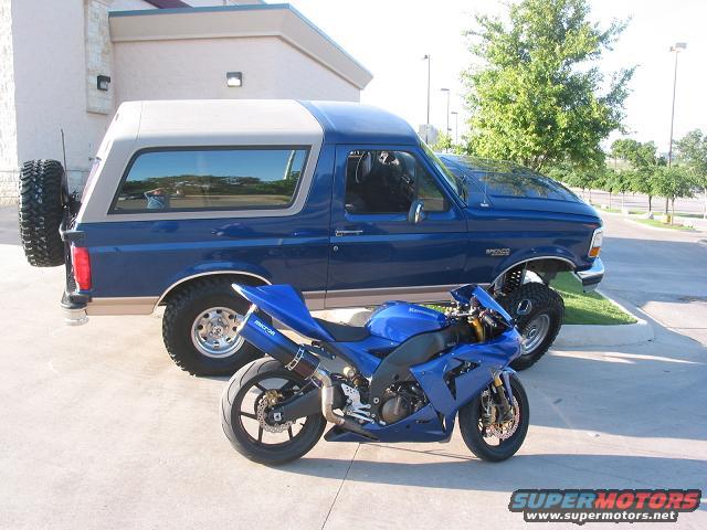 Blue sportbike parked next to a blue Ford Bronco SUV with a spare tire on the back