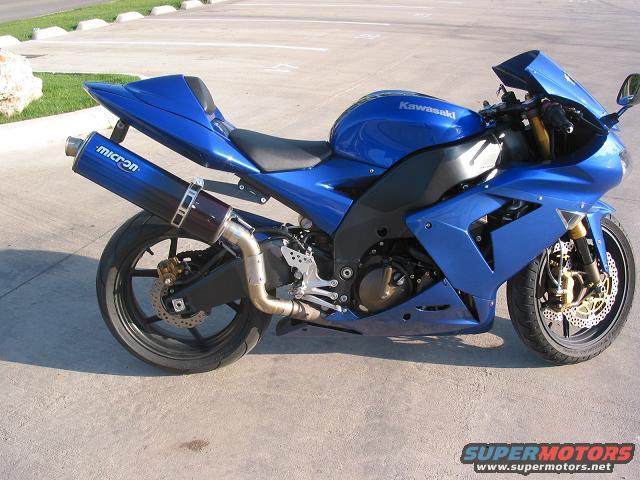 Blue Kawasaki motorcycle with a Micron exhaust parked on concrete
