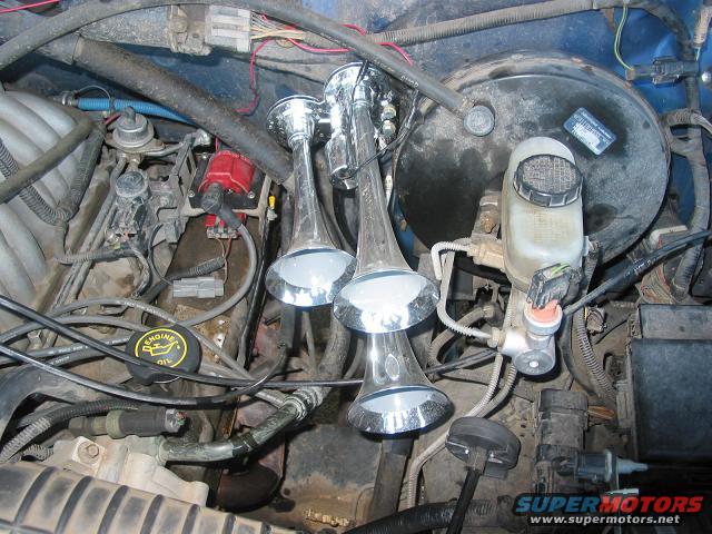 Engine bay showing chrome train horns mounted near brake booster and master cylinder