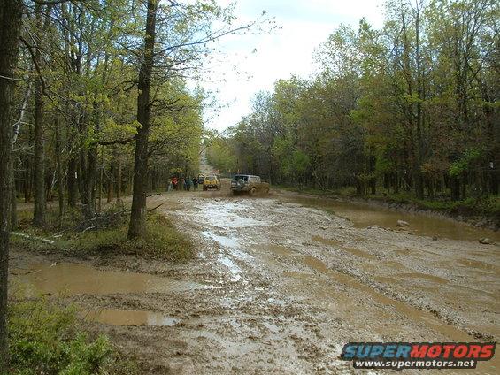 Off-road vehicles navigating a muddy forest road