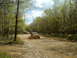 1991 Ford Bronco - Off-road vehicles tackle a challenging muddy trail in a forest setting.