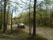 1991 Ford Bronco - Off-road vehicles navigate a challenging muddy trail surrounded by trees.