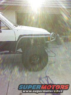 White 1985 Toyota 4Runner, front quarter view, with custom metal bumper and fender flares
