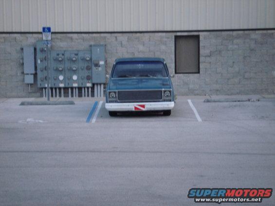 1979 Chevrolet C/K Pickup parked in front of a brick building with utility boxes