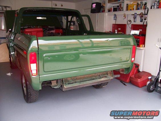 Green 1978 Ford Bronco rear view in garage, hood and door open