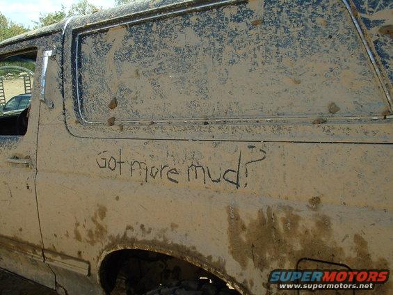 Side view of a mud-covered SUV with "Got more mud?" written on its door