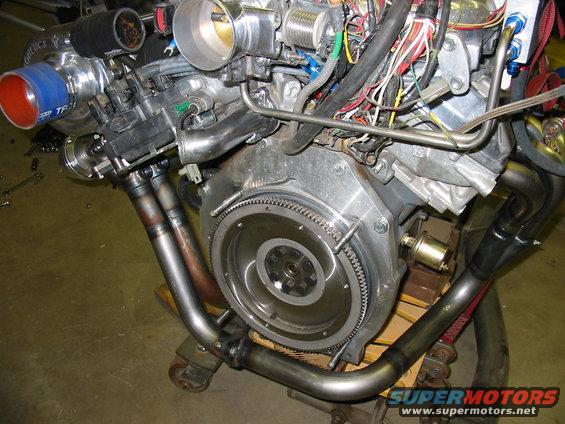 Engine with turbocharger, exhaust manifold, and wiring harness. Visible text: SUPERMOTORS