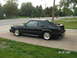1988 Ford Mustang - A black 1988 Ford Mustang coupe is parked on a driveway, viewed from the rear three-quarter angle.