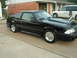 1988 Ford Mustang - A black coupe with aftermarket wheels and a cowl induction hood sits in a driveway.