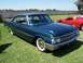 2002 Ford Mustang - This 1961 Ford Fairlane 500 Skyliner coupe is displayed on a grassy field with a red sports car in the background.