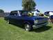 2002 Ford Mustang - A dark blue 1965 Nova coupe is parked on a grassy field with other vehicles in the background.