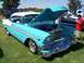 2002 Ford Mustang - A classic 1956 Chevrolet Bel Air, painted in a striking two-tone blue and white, is displayed with its hood open at an outdoor car show.
