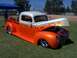 2002 Ford Mustang - A custom hot rod pickup truck with flame graphics and an open hood sits on a grassy field.