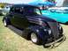 2002 Ford Mustang - A black 1937 Ford Coupe is parked on grass at an outdoor car show with other vehicles present.