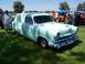2002 Ford Mustang - A light blue sedan delivery van, likely a 1954 model, is displayed on a grassy field at an outdoor event.