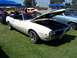 2002 Ford Mustang - White convertible parked on grass with hood open, other vehicles and tents in background.