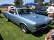 2002 Ford Mustang - A light blue coupe is parked on a grassy field with other vehicles and people around.