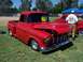 2002 Ford Mustang - A classic red pickup truck with custom flame paint is displayed at an outdoor event.