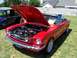 2002 Ford Mustang - A red 1965 Ford Mustang convertible is displayed with its hood open, parked next to another classic vehicle.