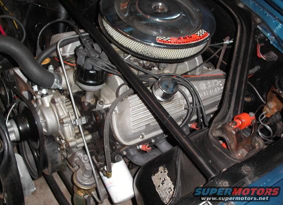 1965 Ford Mustang engine bay with V8 engine, chrome air cleaner, and blue paint