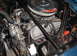 1965 Ford Mustang - Close-up of a 1965 Ford Mustang's engine bay, showing the V8 engine and associated components.
