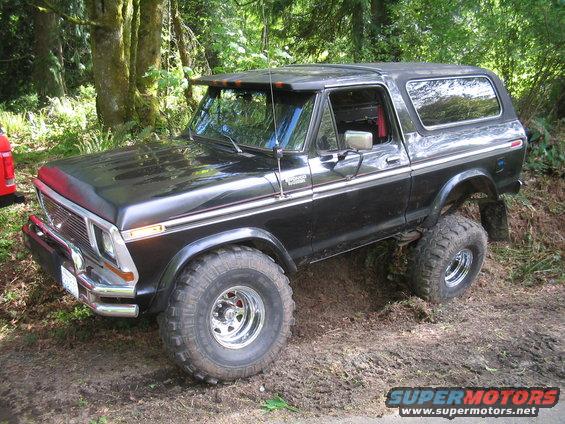 Black Ford Bronco with lifted suspension and off-road tires on a dirt trail